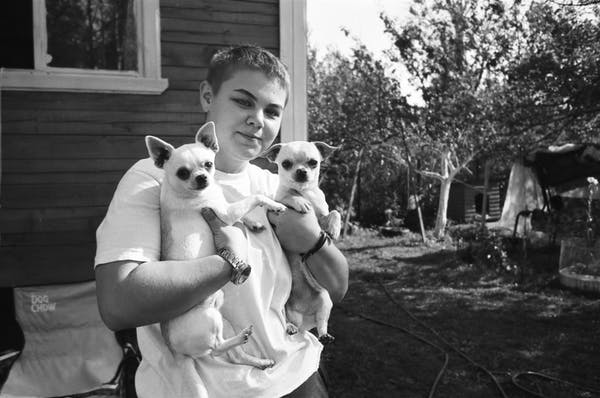 boy carrying two chihuahuas outdoors